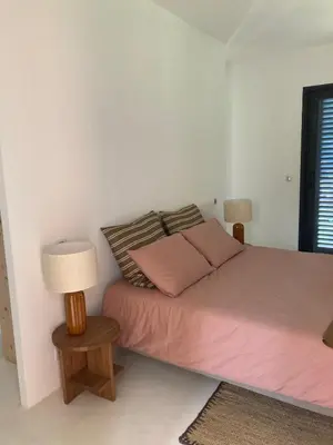 a bedroom with a bed with pink sheets and a lamp at Le Jardin des Graminées in Cabrières-dʼAvignon