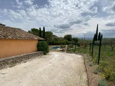 a driveway leading to a villa with a pool at Le Jardin des Graminées in Cabrières-dʼAvignon