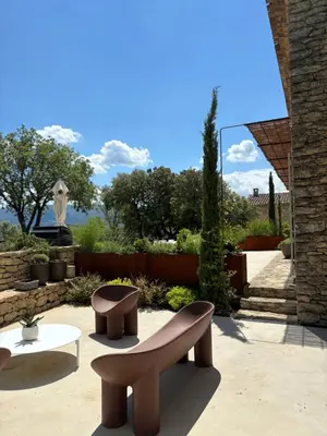 a patio with two benches and a table at Le jardin suspendu in Gordes