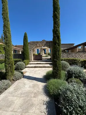 a garden with cypress trees and a house at Le jardin suspendu in Gordes