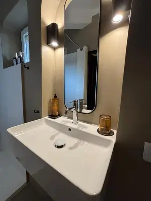 a bathroom with a white sink and a mirror at Le jardin suspendu in Gordes