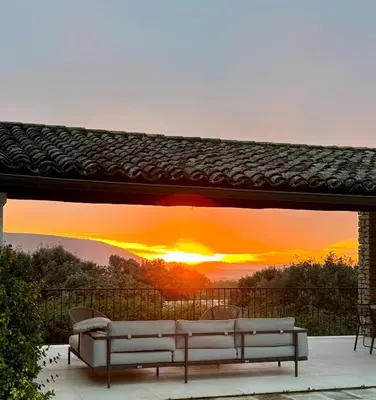 a view of a sunset from a patio with couches at Le jardin suspendu in Gordes
