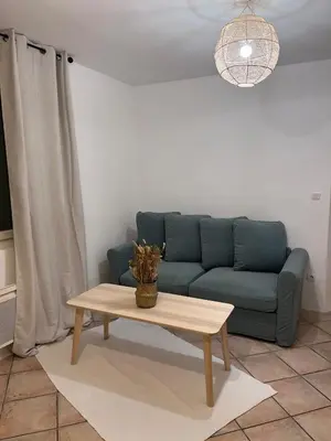 a living room with a blue couch and a coffee table at 2 rooms very well located in L'Isle-sur-la-Sorgue in LʼIsle-sur-la-Sorgue