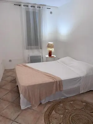 a bedroom with a bed with a lamp and a window at 2 rooms very well located in L'Isle-sur-la-Sorgue in LʼIsle-sur-la-Sorgue