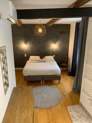 a bedroom with a bed in a room with a rug at restaurant Dame L'Oie in Pernes-les-Fontaines