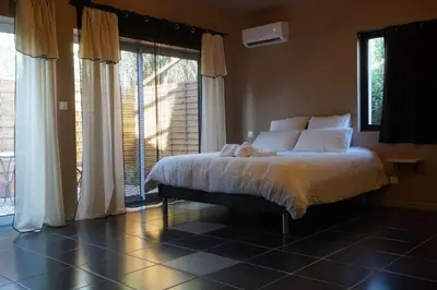 a bedroom with a bed with white pillows and windows at Chambre de charme indépendante Alba avec baignoire îlot - Domaine Astra, Grans in Grans