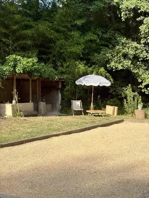 an umbrella and a chair sitting on the grass at Quiet Provencal bastide with pool close Lourmarin in Lauris