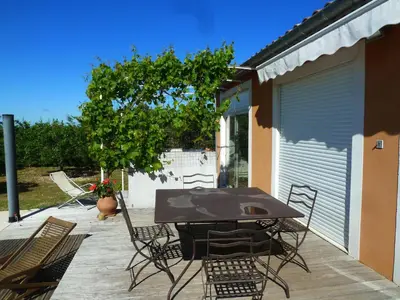 a patio with a table and chairs and a tree at Iris Caromb in Caromb