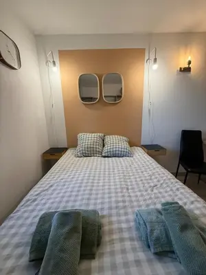 a bedroom with a bed with two mirrors on the wall at Le Clos D'AIX Studio 108 in Aix-en-Provence