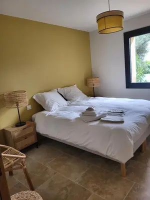 a bedroom with a white bed with two hats on it at La Bastide des Amis in Caromb