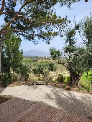 a wooden deck with a bench in front of a fence at La Bastide des Amis in Caromb