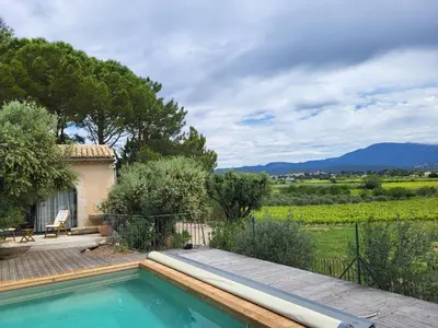 a swimming pool in front of a house at La Bastide des Amis in Caromb