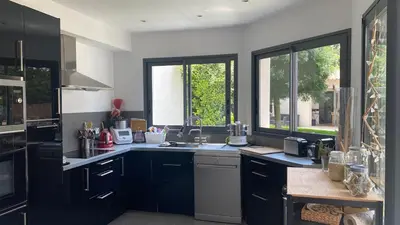 a kitchen with black and white counters and windows at 3 bedroom villa with pool in Aix-en-Provence