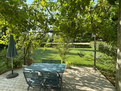 a patio with a table and chairs and an umbrella at Maison d'hôte en Provence avec petit déjeuner in Mollégès
