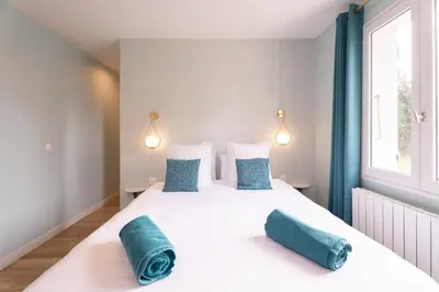 a bedroom with a large white bed with blue pillows at Olyma - Spacieuse - Familiale - Piscine & Climatisé in Éguilles