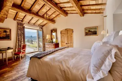 a bedroom with a bed and a large window at La Bastide in Oppède
