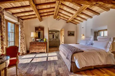 a bedroom with a large bed and a wooden ceiling at La Bastide in Oppède