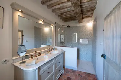 a bathroom with two sinks and a large mirror at La Bastide in Oppède