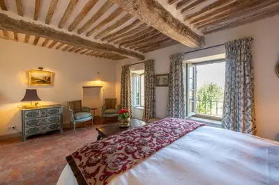 a bedroom with a large bed and a window at La Bastide in Oppède