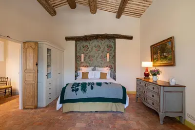 a bedroom with a bed and a dresser at La Bastide in Oppède
