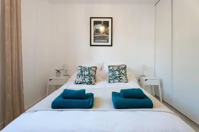 a bedroom with a white bed with blue pillows at La maison d'Alice - Calme - Climatisation - Parking privatif in Velaux