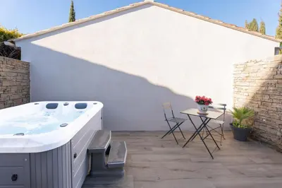 a hot tub on a patio with a table at La maison d'Alice - Calme - Climatisation - Parking privatif in Velaux