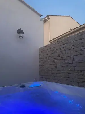 a tub with blue lighting in a room with a brick wall at La maison d'Alice - Calme - Climatisation - Parking privatif in Velaux