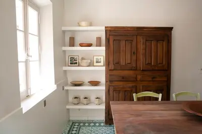 a dining room with a table and a wooden cabinet at Le mas provençal d'Aurélie in Carpentras