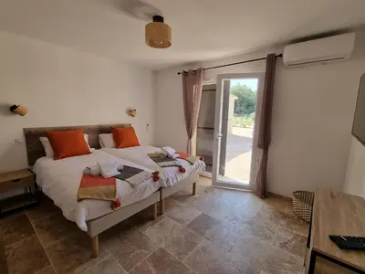 a bedroom with a bed and a sliding glass door at L'Orée du Ventoux - Crillon-le-Brave in Crillon-le-Brave