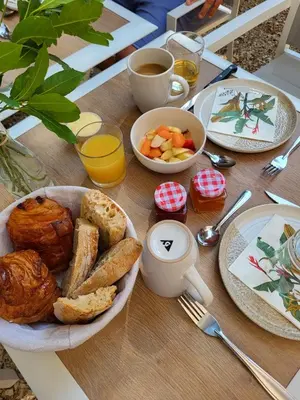 a table with a breakfast of bread and toast and coffee at L'Orée du Ventoux - Crillon-le-Brave in Crillon-le-Brave