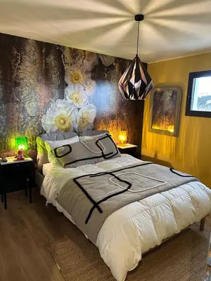 a bedroom with a large bed with flowers on the wall at Chambres d'hôte in Châteauneuf-de-Gadagne
