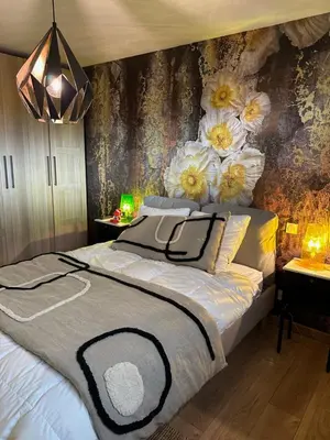 a bedroom with a bed with flowers on the wall at Chambres d'hôte in Châteauneuf-de-Gadagne