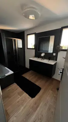 a bathroom with a tub and a sink and a television at Chambres d'hôte in Châteauneuf-de-Gadagne