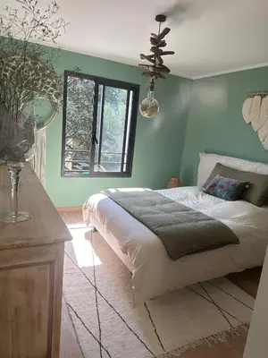 a bedroom with a bed with green walls and a window at Chambres d'hôte in Châteauneuf-de-Gadagne
