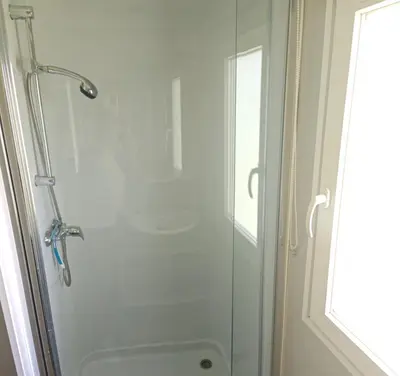 a shower with a glass door in a bathroom at Mobilhome 6 personnes in Cheval-Blanc