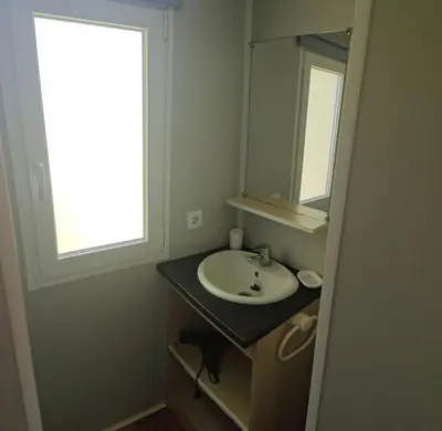 a bathroom with a sink and a mirror at Mobilhome 6 personnes in Cheval-Blanc
