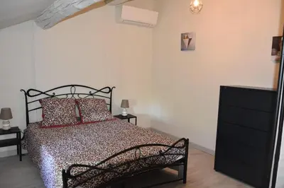 a bedroom with a black bed and two night stands at Gite chez les Truph in Entraigues-sur-la-Sorgue