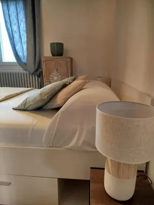 a bedroom with a bed and a table with a lamp at Villa MOOREA pool barbecue PROVENCE in Entraigues-sur-la-Sorgue