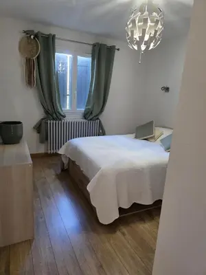 a bedroom with a bed and a window and a chandelier at Villa MOOREA pool barbecue PROVENCE in Entraigues-sur-la-Sorgue