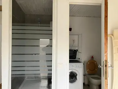 a bathroom with a washing machine and a toilet at Maison de village à Pertuis in Pertuis