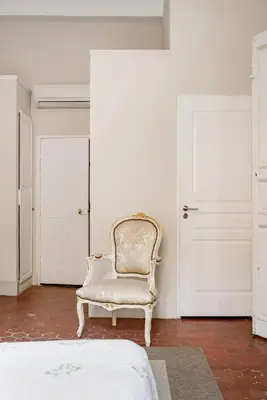 a white chair sitting in a room with two doors at Bel appartement près du Cours Mirabeau in Aix-en-Provence