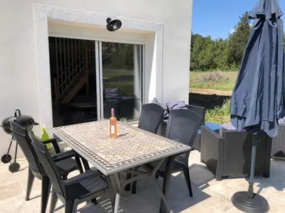 a table and chairs on a patio with a umbrella at Maison de charme in Monteux