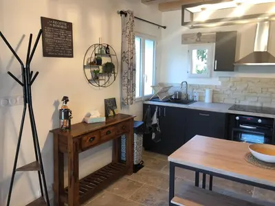 a kitchen with a wooden table and a counter top at Maison de charme in Monteux