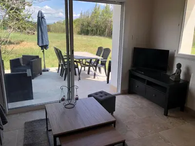 a living room with a television and a table with chairs at Maison de charme in Monteux