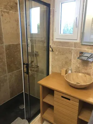 a bathroom with a glass shower and a sink at Maison de charme in Monteux