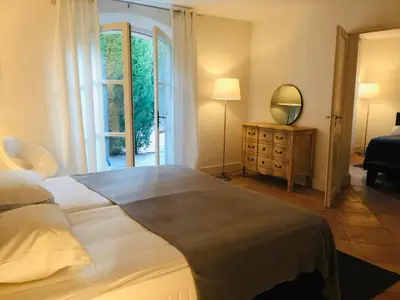 a bedroom with a large bed and a mirror at Bastide des Lauves in Aix-en-Provence