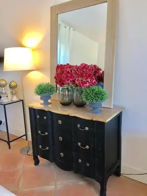 a dresser with two vases of flowers in front of a mirror at Bastide des Lauves in Aix-en-Provence
