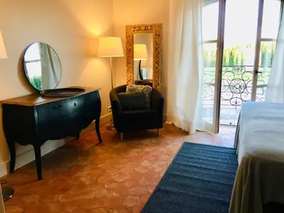 a bedroom with a dresser and a chair and a mirror at Bastide des Lauves in Aix-en-Provence