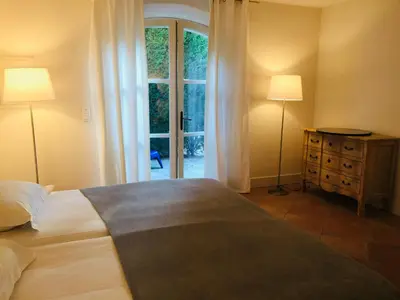 a bedroom with a bed and two lamps and a window at Bastide des Lauves in Aix-en-Provence