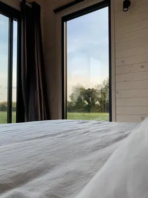 a bed in a room with a large window at Lodge en Provence in Mouriès